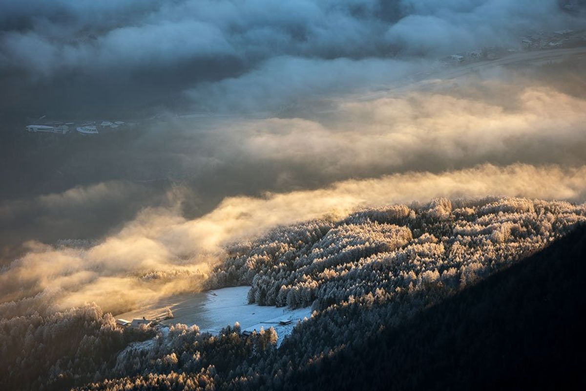 Die ersten Sonnenstrahlen des Tages tauchen den Nebel im Tal in goldenes Licht